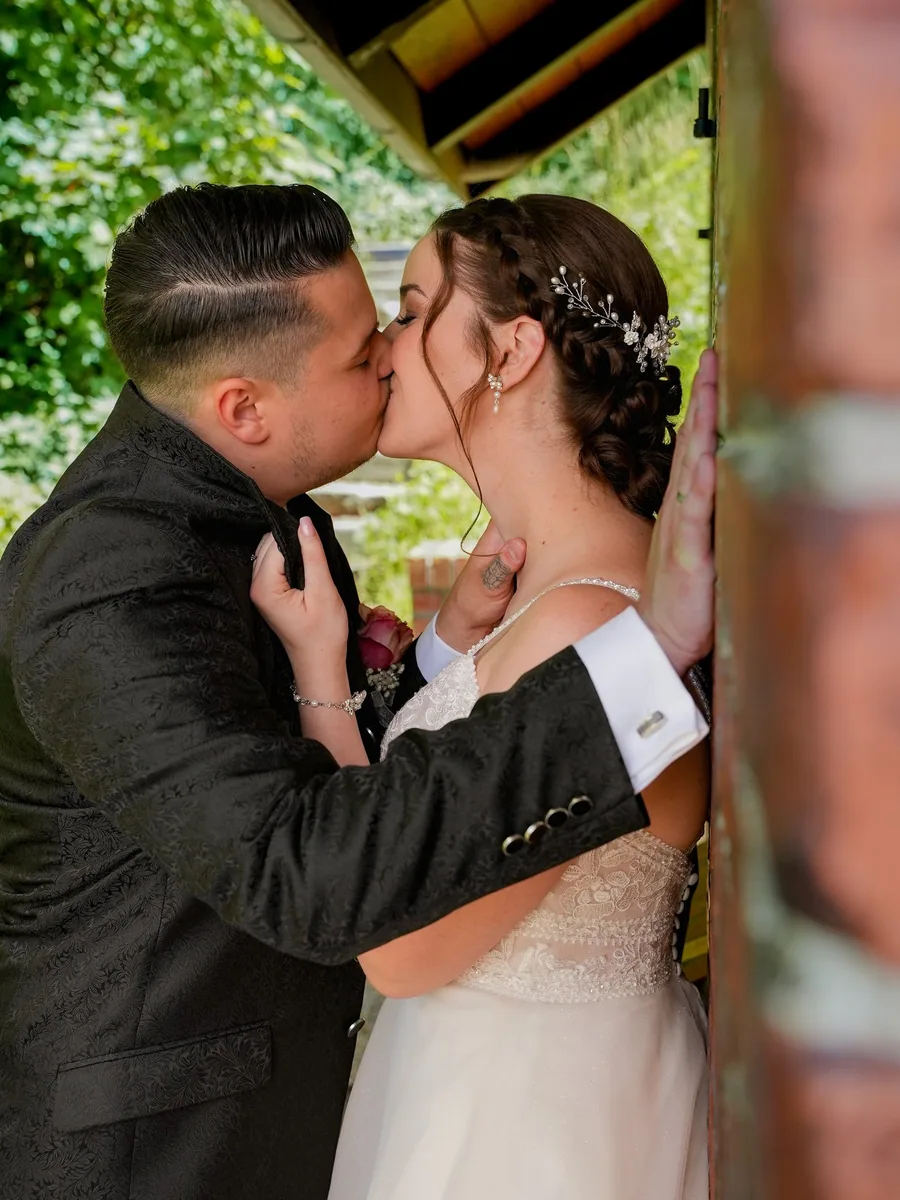 Kuss an einer Holzwand – Hochzeit Franky und Angelika