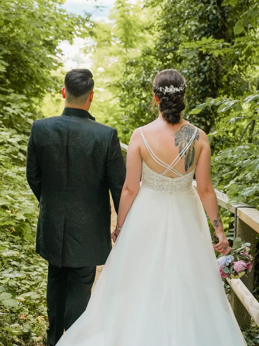 Das Brautpaar von hinten im Grünen – Hochzeit Franky und Angelika